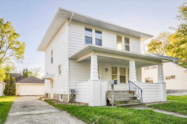 american foursquare style home with a porch, an outdoor structure, and a garage