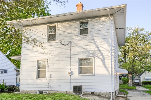 back of house featuring a chimney and central AC