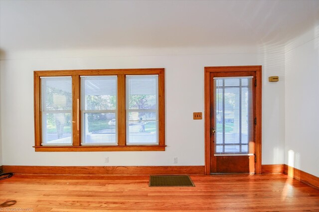 doorway to outside with wood finished floors and baseboards