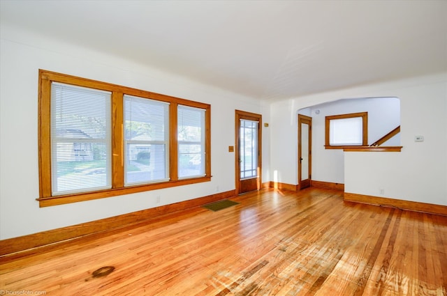 unfurnished living room featuring light wood-type flooring and baseboards