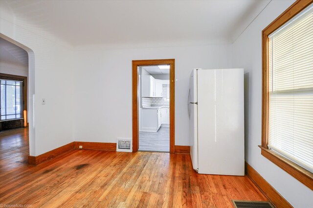 empty room featuring light wood-type flooring and baseboards