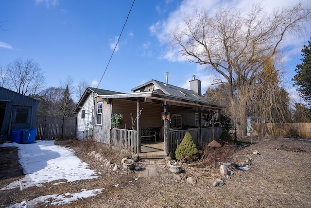 3110 Sigma Rd, Kalkaska, MI 49646 - view of front of house featuring a chimney, fence, and a porch