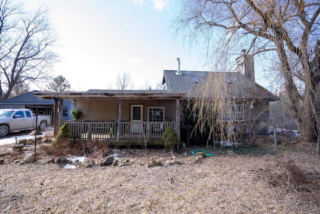 3110 Sigma Rd, Kalkaska, MI 49646 - view of front of house featuring a chimney, a shingled roof, and a wooden deck