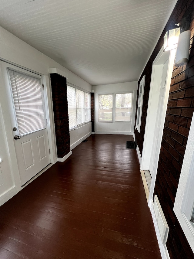 unfurnished sunroom featuring hardwood / wood-style flooring and baseboards