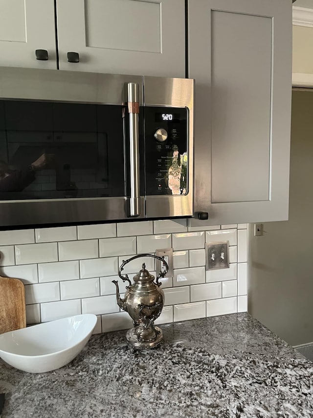 14074 Barbara St, Livonia, MI 48154 - kitchen view of tasteful backsplash, stainless steel microwave, and dark stone countertops