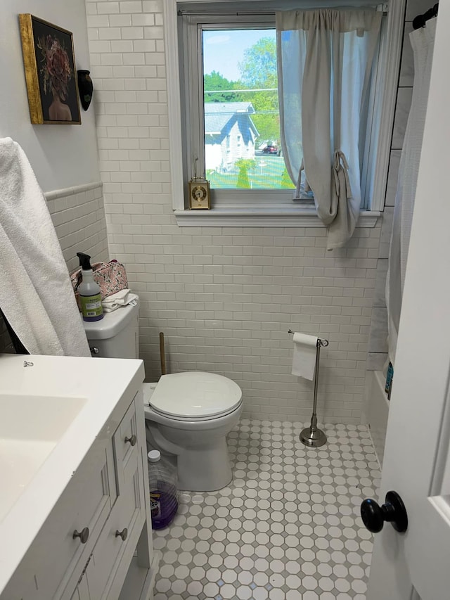 14074 Barbara St, Livonia, MI 48154 - bathroom with tile walls, toilet, vanity, tile patterned floors, and shower / bath combo