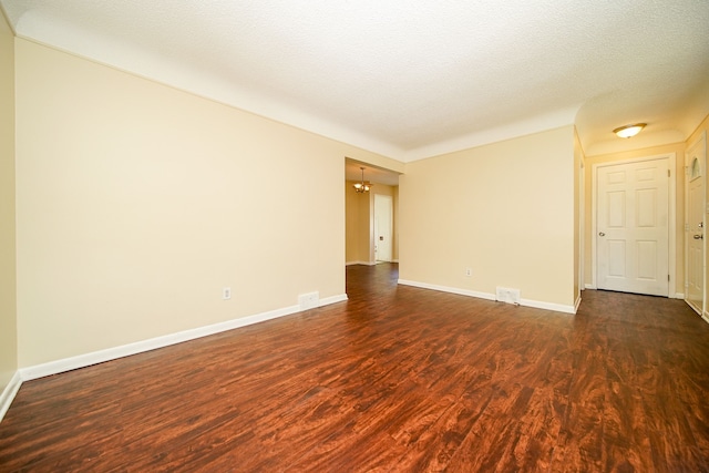 empty room featuring dark wood-style floors and baseboards