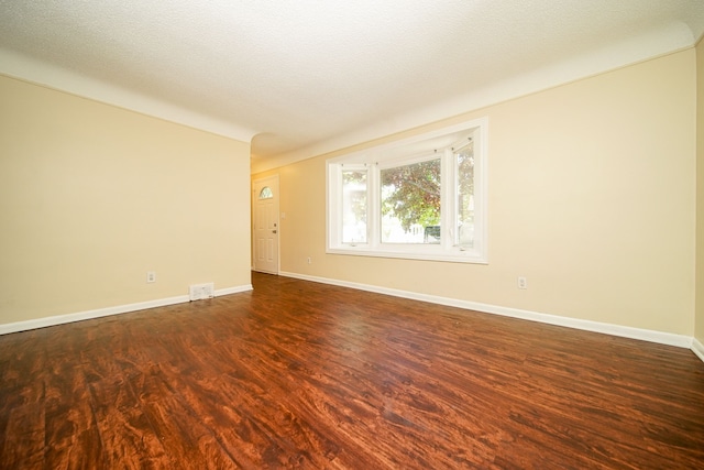 spare room with dark wood-style floors and baseboards