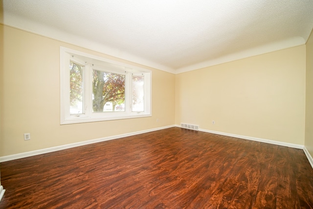 spare room with dark wood-style floors and baseboards