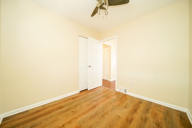 unfurnished bedroom with baseboards, light wood finished floors, a ceiling fan, and a closet