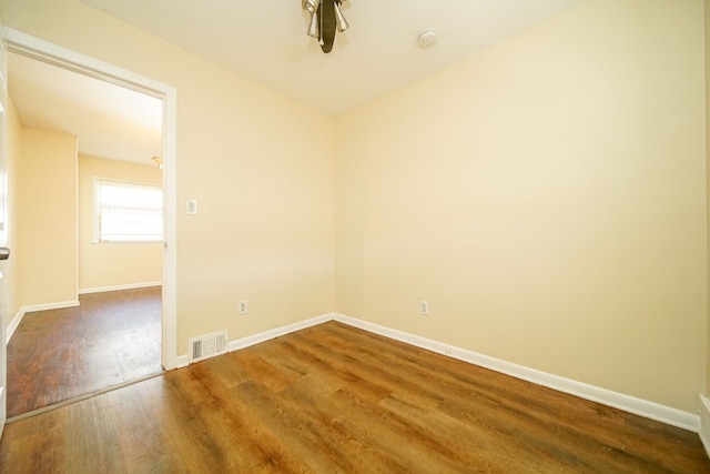 unfurnished room with wood finished floors, baseboards, and a smoke detector