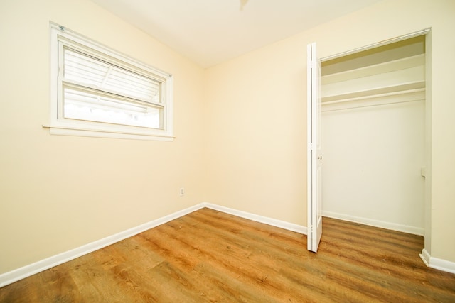 unfurnished bedroom featuring a closet, light wood finished floors, and baseboards
