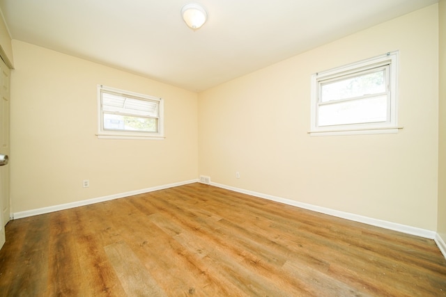 unfurnished room with wood finished floors and baseboards