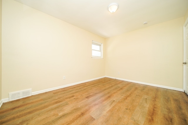 unfurnished room featuring baseboards and light wood finished floors