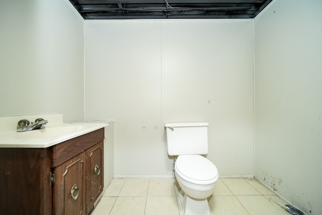 bathroom featuring vanity, toilet, tile patterned floors, and baseboards