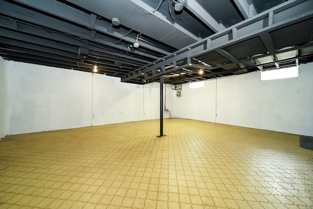 finished below grade area featuring tile patterned floors and gas meter