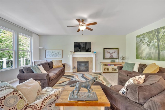 1060 Tinley Blvd, Oxford, MI 48371 - living room with baseboards, a tiled fireplace, a ceiling fan, and carpet flooring