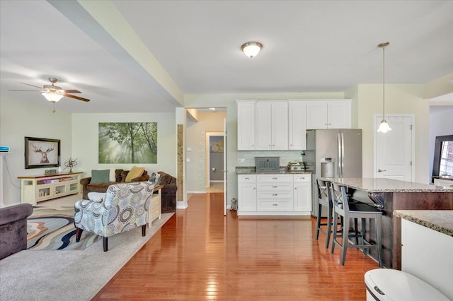 1060 Tinley Blvd, Oxford, MI 48371 - kitchen with open floor plan, light stone countertops, light wood finished floors, and ceiling fan