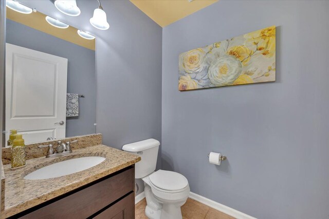 1060 Tinley Blvd, Oxford, MI 48371 - bathroom with baseboards, toilet, vanity, and tile patterned floors