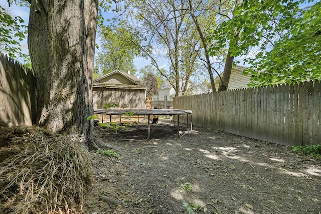 fenced backyard with a trampoline