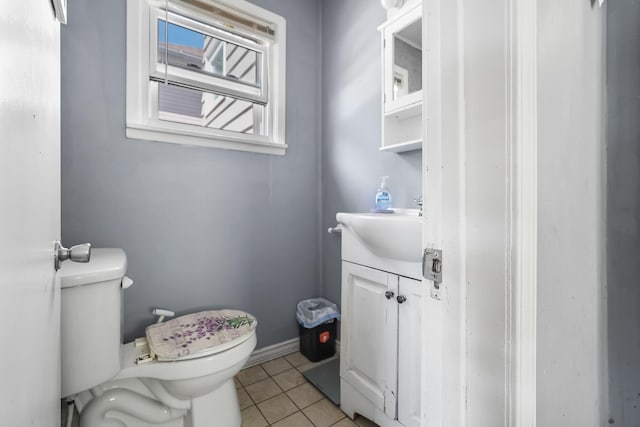 half bath featuring tile patterned floors, toilet, and vanity