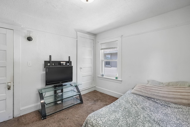 bedroom featuring carpet flooring, baseboards, and a textured ceiling