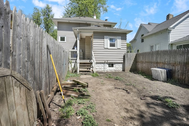 rear view of house featuring a fenced backyard