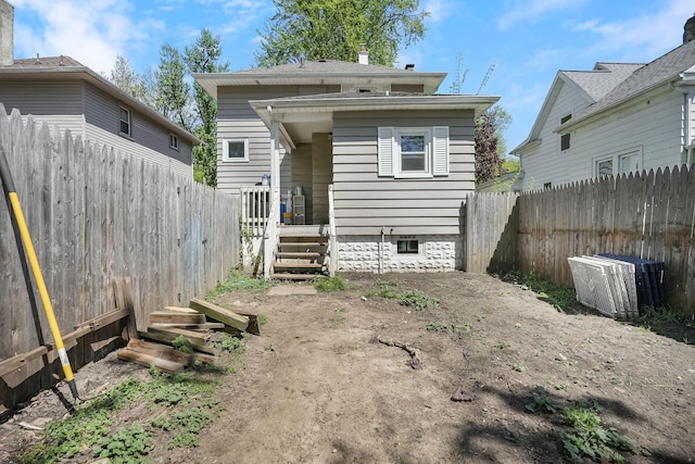 back of house featuring a fenced backyard and a chimney