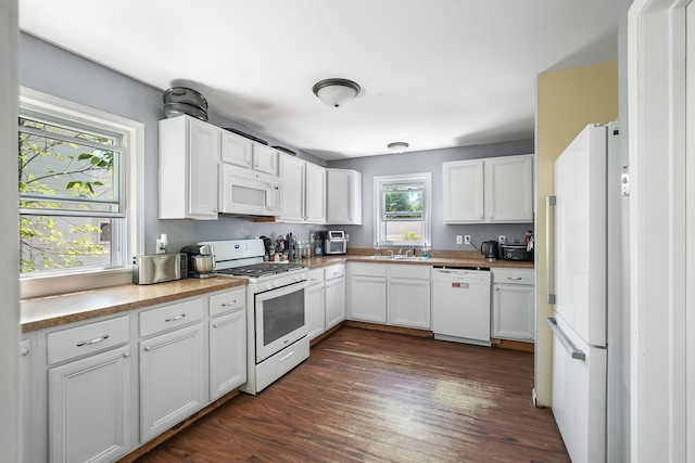 kitchen with white appliances, a sink, white cabinets, dark wood-type flooring, and light countertops
