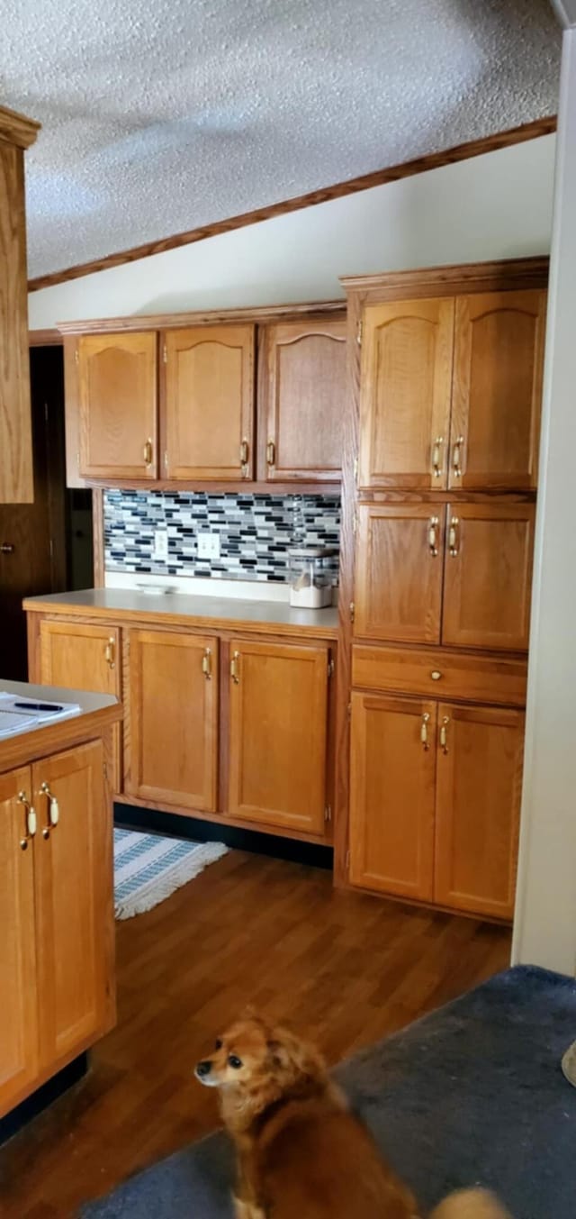 700 S Arent Rd, Watervliet, MI 49098 - kitchen featuring dark wood-type flooring, tasteful backsplash, a textured ceiling, light countertops, and ornamental molding