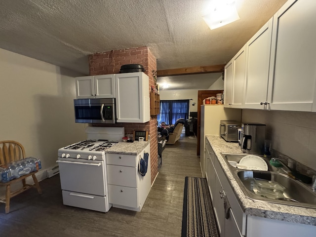 127 N Camburn St, Stanton, MI 48888 - kitchen featuring stainless steel microwave, white gas range oven, a sink, white cabinets, and a textured ceiling