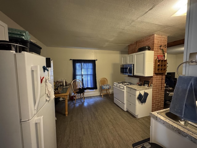 127 N Camburn St, Stanton, MI 48888 - kitchen with white appliances, dark wood finished floors, white cabinets, and light countertops