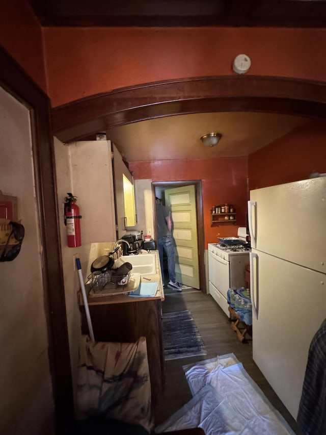 127 N Camburn St, Stanton, MI 48888 - kitchen with white appliances, a sink, and dark wood-type flooring