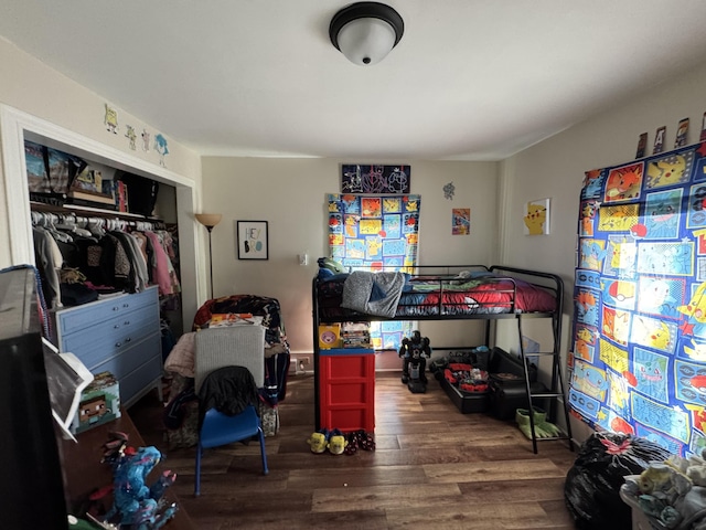 bedroom with wood finished floors and a closet