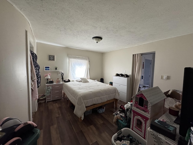 bedroom with dark wood-type flooring and a textured ceiling