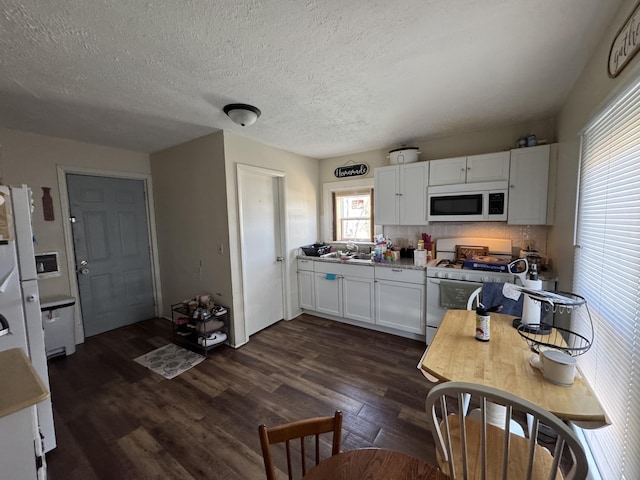 kitchen featuring white appliances, dark wood-style flooring, white cabinetry, a textured ceiling, and backsplash