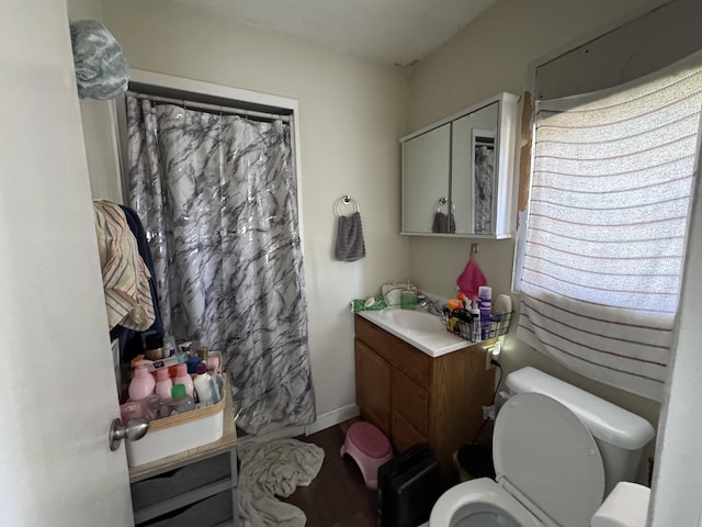 bathroom featuring wood finished floors, toilet, vanity, and a shower with curtain