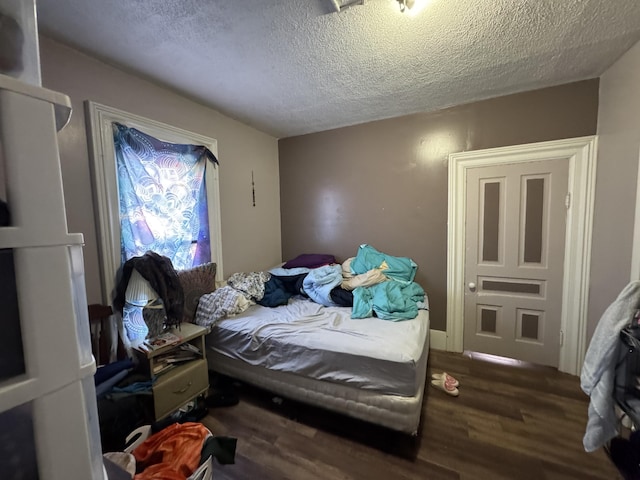 bedroom with wood finished floors and a textured ceiling
