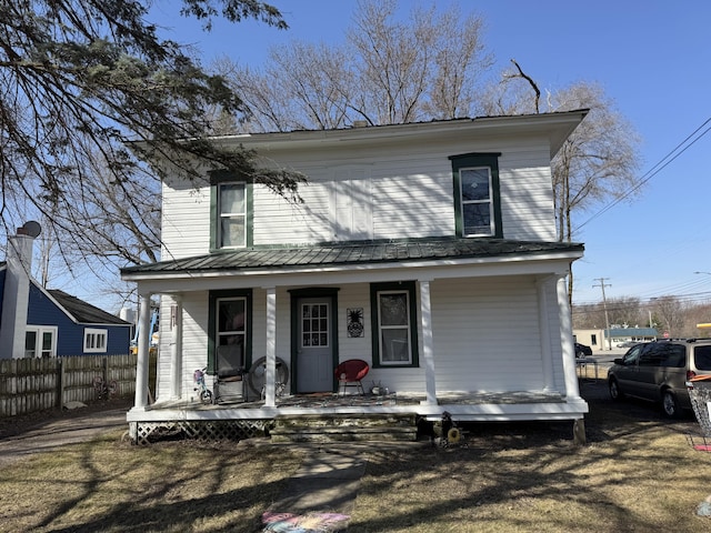 view of front facade featuring a porch and fence