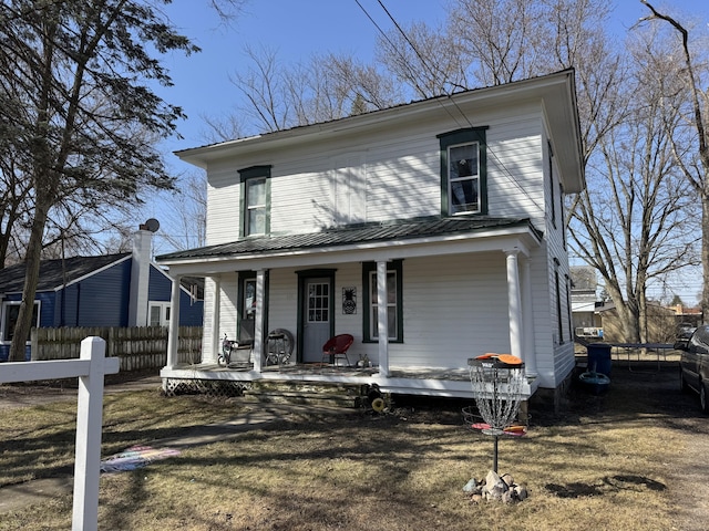 view of front of home with fence, a porch, and metal roof
