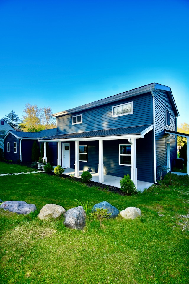 view of front of property with a front lawn, a porch, and metal roof