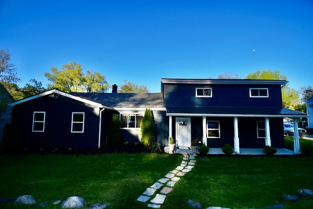 traditional-style home featuring a front lawn, a porch, and a chimney
