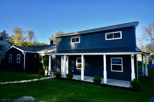 view of front of property with a front yard, a porch, and metal roof