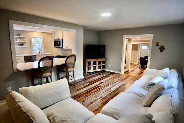 living area with wood finished floors, recessed lighting, and baseboards