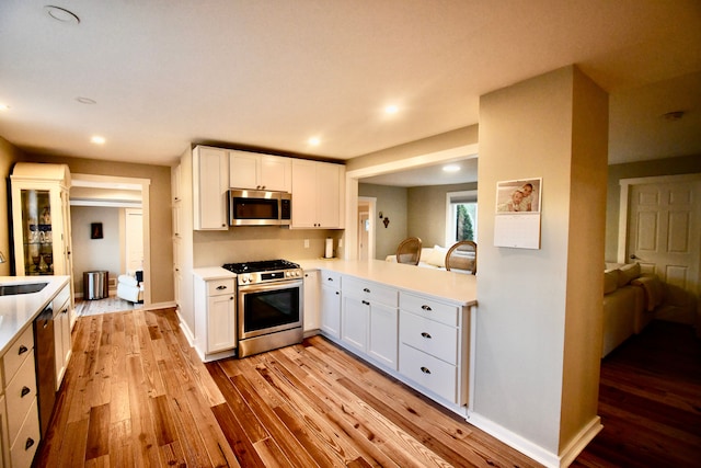 kitchen featuring stainless steel appliances, light wood-style flooring, light countertops, and recessed lighting