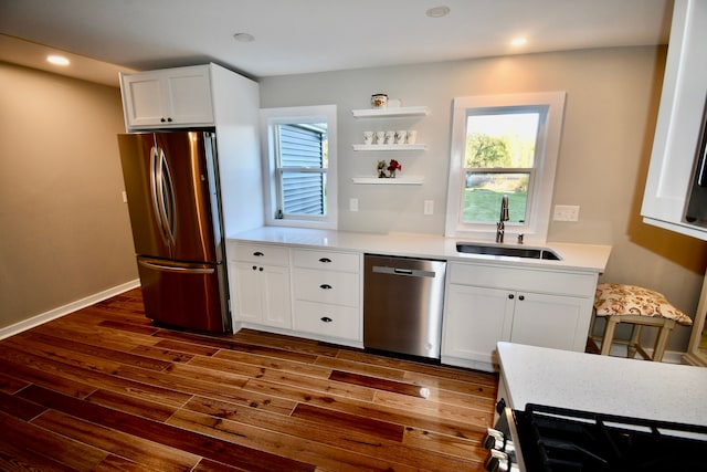 kitchen featuring appliances with stainless steel finishes, a sink, dark wood-style flooring, white cabinetry, and open shelves
