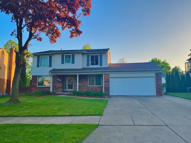 traditional-style home featuring brick siding, a garage, driveway, and a front yard