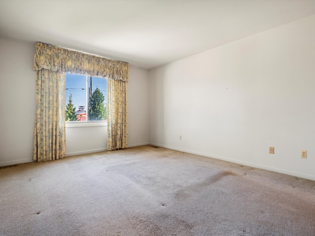 empty room featuring carpet flooring and baseboards