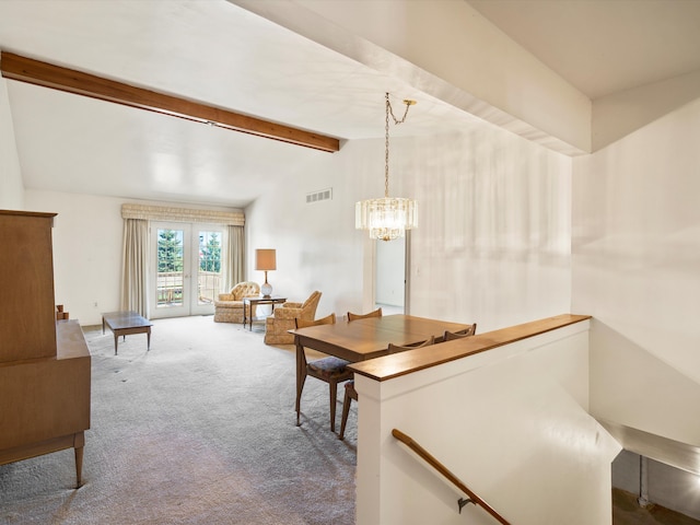 carpeted dining room featuring a chandelier