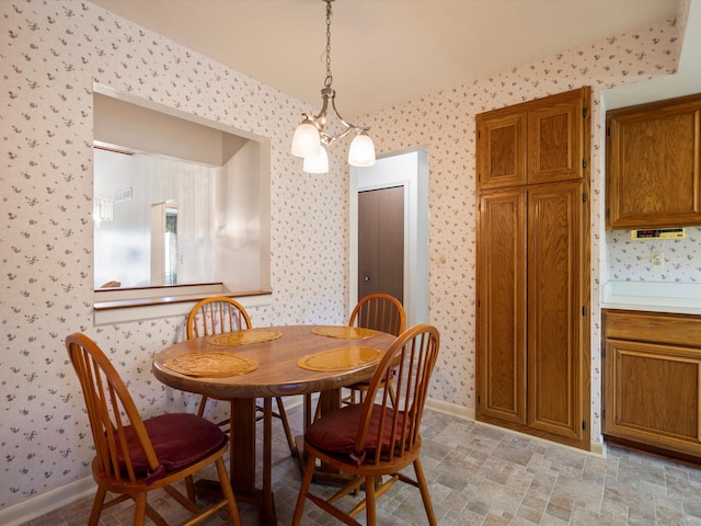 dining area with wallpapered walls, baseboards, and a chandelier